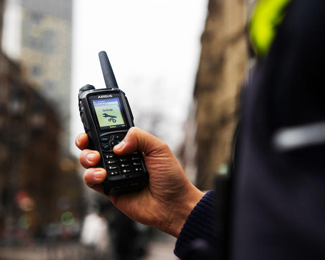Police officer scrolling the menu of a TH9 TETRA terminal Police officer scrolling the menu of a TH9 TETRA terminal